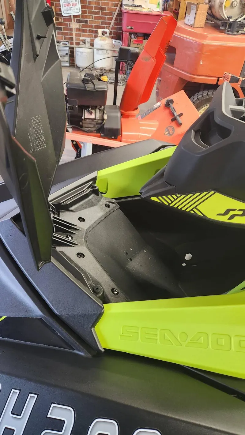 Slide: The Image of 2023 Sea-Doo SPARK 3UP TRIXX SS, lime green, open storage compartment in garage setting. - 7