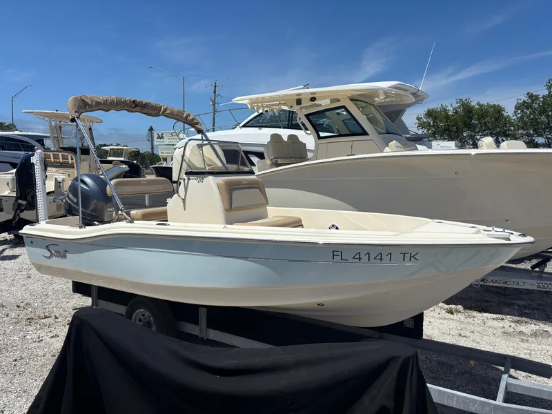 Slide: The Image of 2022 Scout 175 Sportfish boat on display in a marina under clear blue skies. - 0