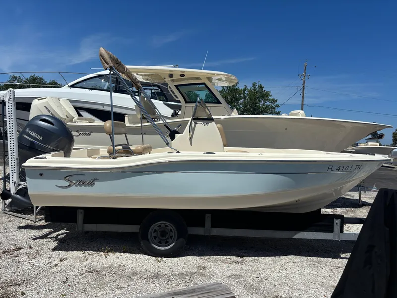 Slide: The Image of 2022 Scout 175 Sportfish boat on trailer with Yamaha engine, parked outdoors. - 1