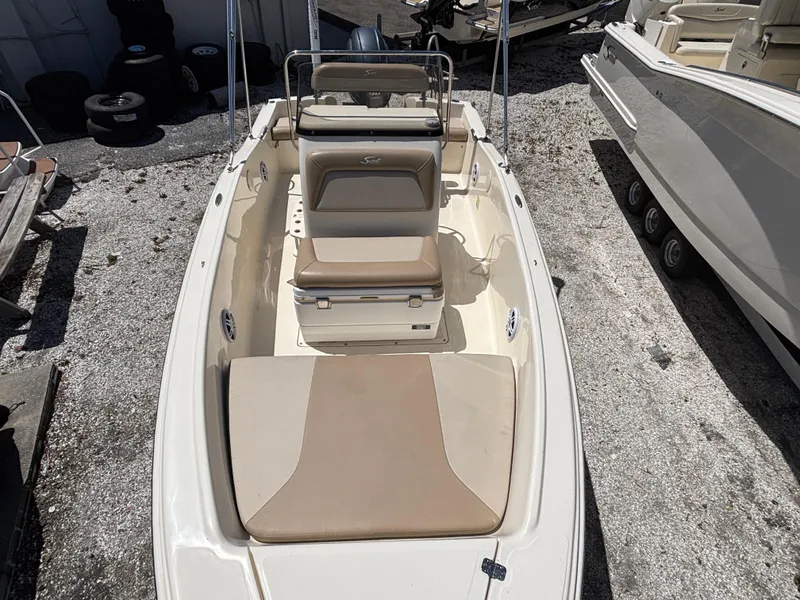 Slide: The Image of 2022 Scout 175 Sportfish boat with beige seating, docked on gravel. - 10