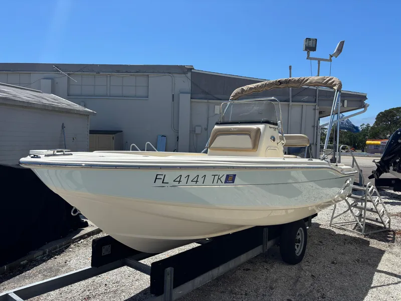 Slide: The Image of 2022 Scout 175 Sportfish boat on trailer, parked outdoors under clear blue sky. - 2