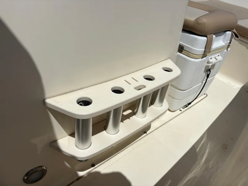 Slide: The Image of 2022 Scout 175 Sportfish boat interior with rod holders and cooler. - 20