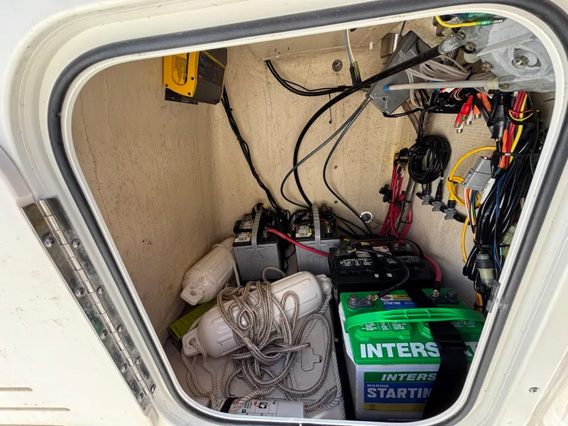 Slide: The Image of 2022 Scout 175 Sportfish boat compartment with batteries, ropes, and electrical wiring. - 21