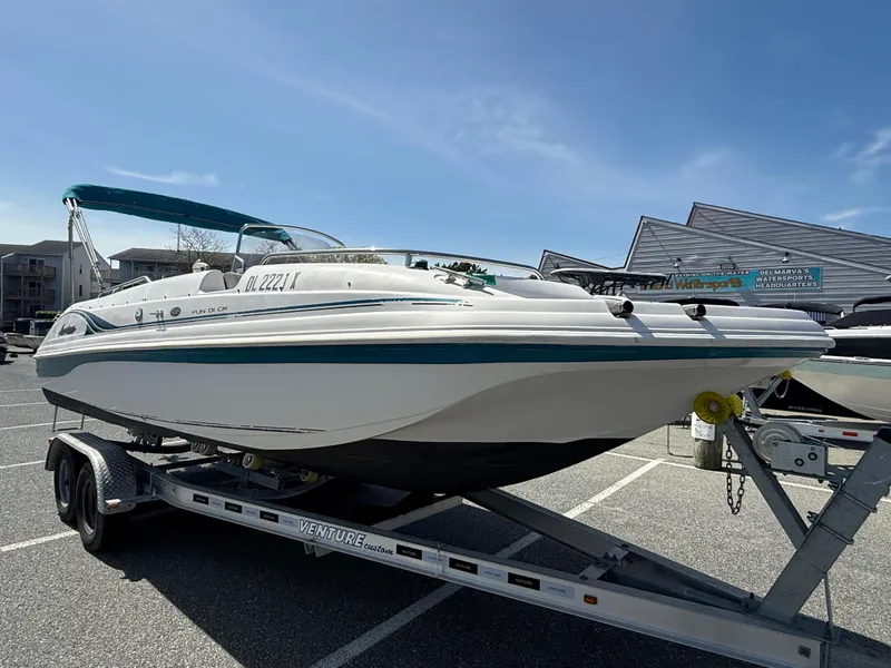 Slide: The Image of 2002 Hurricane Fun Deck GS211 boat on trailer in parking lot under clear sky. - 1
