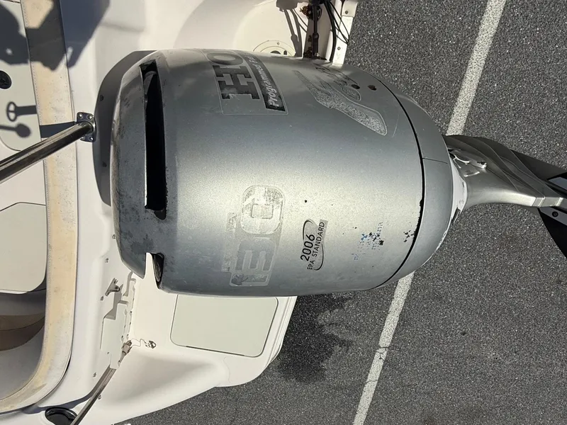 Slide: The Image of Outboard motor on a 2002 Hurricane Fun Deck GS211 boat, parked on asphalt. - 12