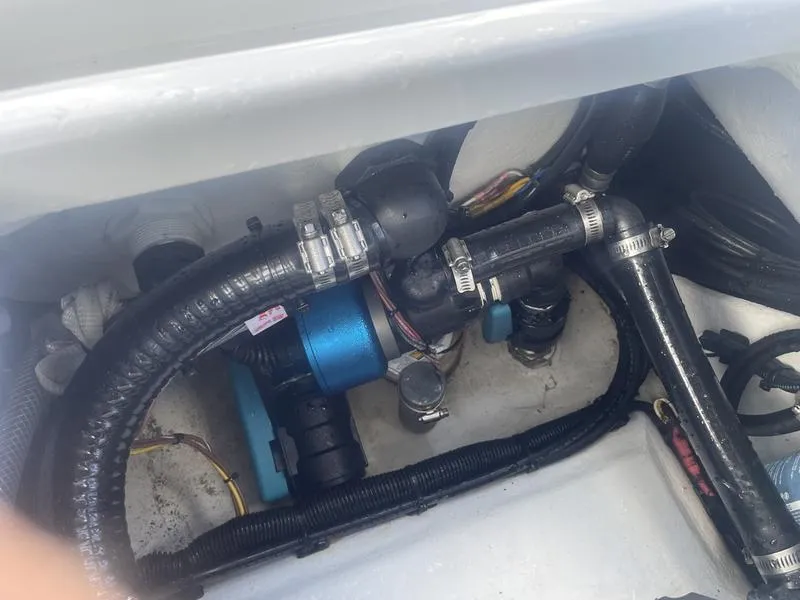 Slide: The Image of Engine compartment of 2024 Islamorada Boatworks Morada 18, showcasing hoses and components. - 13