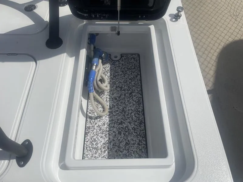 Slide: The Image of 2024 Islamorada Boatworks Morada 18 storage compartment with hose, open lid, and textured interior. - 9