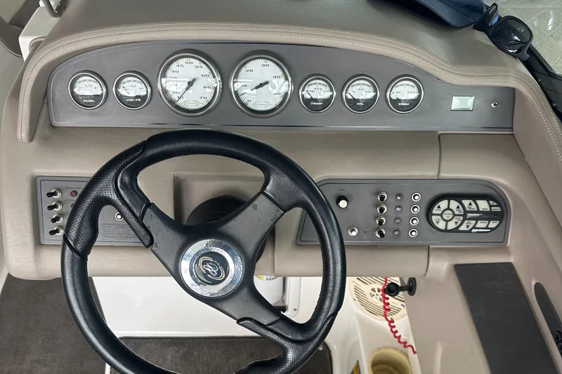 Slide: The Image of Steering wheel and dashboard of a 2002 Cobalt 246 boat with gauges and controls. - 13