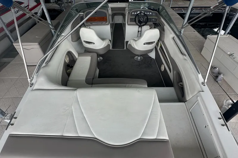 Slide: The Image of 2002 Cobalt 246 boat interior with white seating and steering wheel. - 18