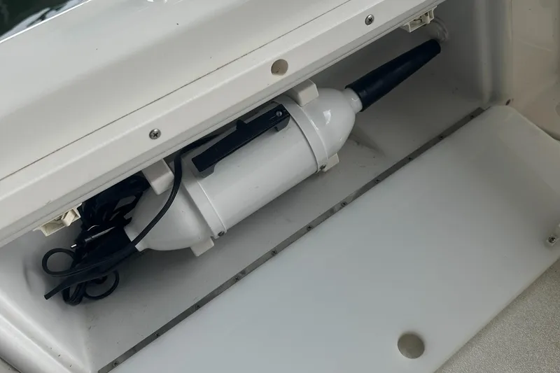 Slide: The Image of Storage compartment in a 2002 Cobalt 246 boat with a white cylindrical device. - 23