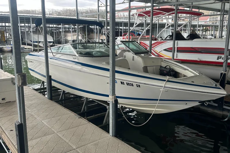 Slide: The Image of 2002 Cobalt 246 boat docked in a marina, featuring a sleek white and blue design. - 4