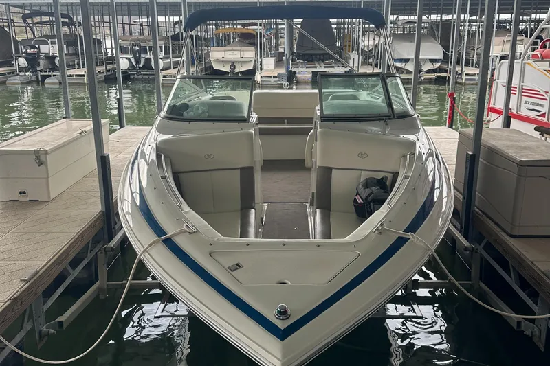 Slide: The Image of 2002 Cobalt 246 boat docked in marina, featuring sleek design and spacious seating. - 6