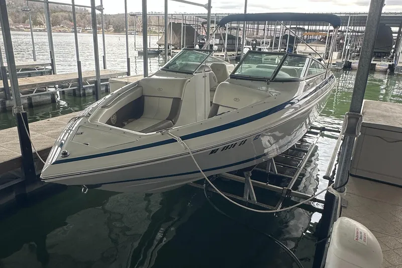 Slide: The Image of 2002 Cobalt 246 boat docked in a marina, featuring sleek design and spacious seating. - 7