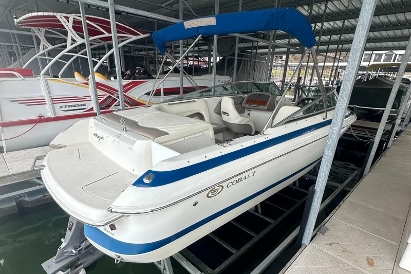 Slide: The Image of 2002 Cobalt 246 boat with blue canopy docked in marina. - 9