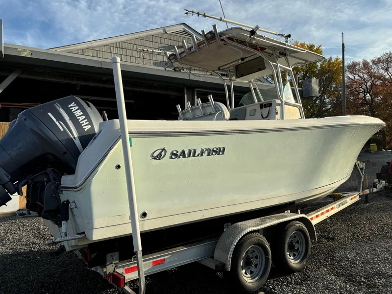 Slide: The Image of 2009 Sailfish 2660 boat on trailer with Yamaha outboard motor, parked outdoors. - 2