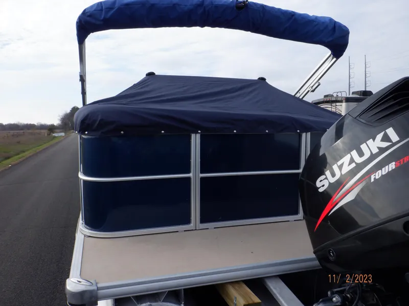 Slide: The Image of 2013 Sylvan Signature 8523 LZ pontoon boat with Suzuki outboard motor on a road. - 11