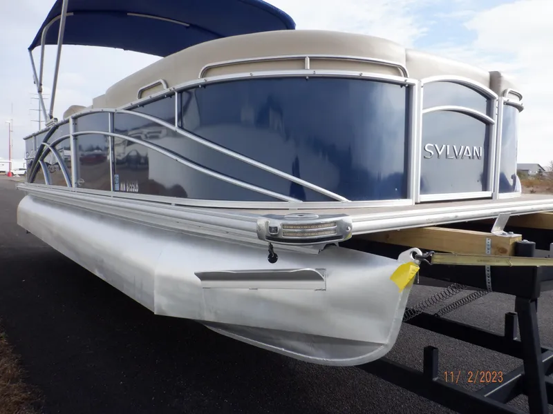 Slide: The Image of 2013 Sylvan Signature 8523 LZ pontoon boat with blue and white exterior on a trailer. - 18