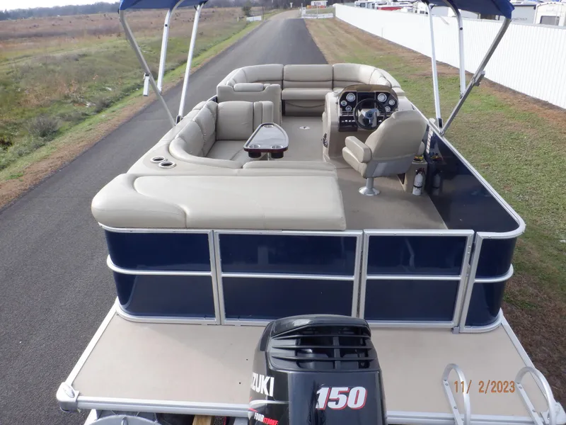 Slide: The Image of 2013 Sylvan Signature 8523 LZ pontoon boat with Suzuki 150 engine on a rural road. - 3