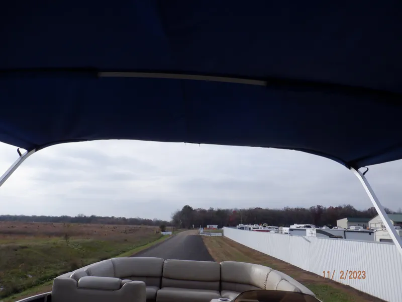 Slide: The Image of 2013 Sylvan Signature 8523 LZ boat with canopy on a rural road. - 31