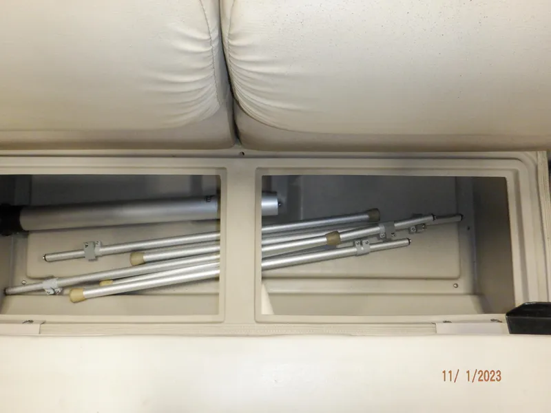 Slide: The Image of Storage compartment with metal poles in a 2013 Sylvan Signature 8523 LZ boat. - 47
