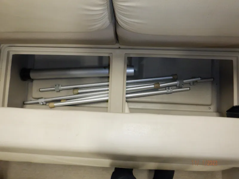 Slide: The Image of Storage compartment with metal poles in a 2013 Sylvan Signature 8523 LZ boat. - 48
