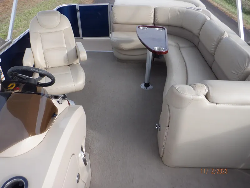 Slide: The Image of 2013 Sylvan Signature 8523 LZ pontoon boat interior with beige seating and steering console. - 6