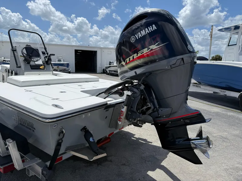 Slide: The Image of 2023 Hewes 18 Redfisher boat with Yamaha outboard motor, parked outdoors under a cloudy sky. - 10