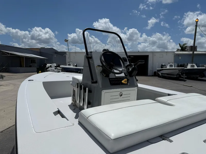 Slide: The Image of 2023 Hewes 18 Redfisher boat with white seating, parked outdoors under a cloudy sky. - 12