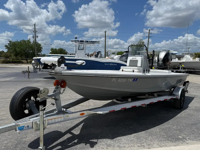 Slide: The Image of 2023 Hewes 18 Redfisher boat on trailer under a partly cloudy sky. - 13