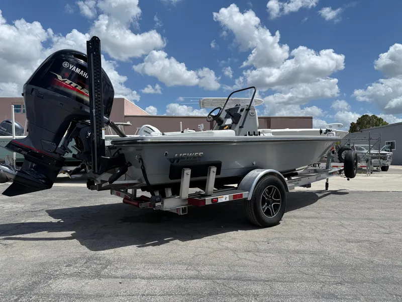 Slide: The Image of 2023 Hewes 18 Redfisher boat on trailer, Yamaha outboard, parked outdoors under cloudy sky. - 7