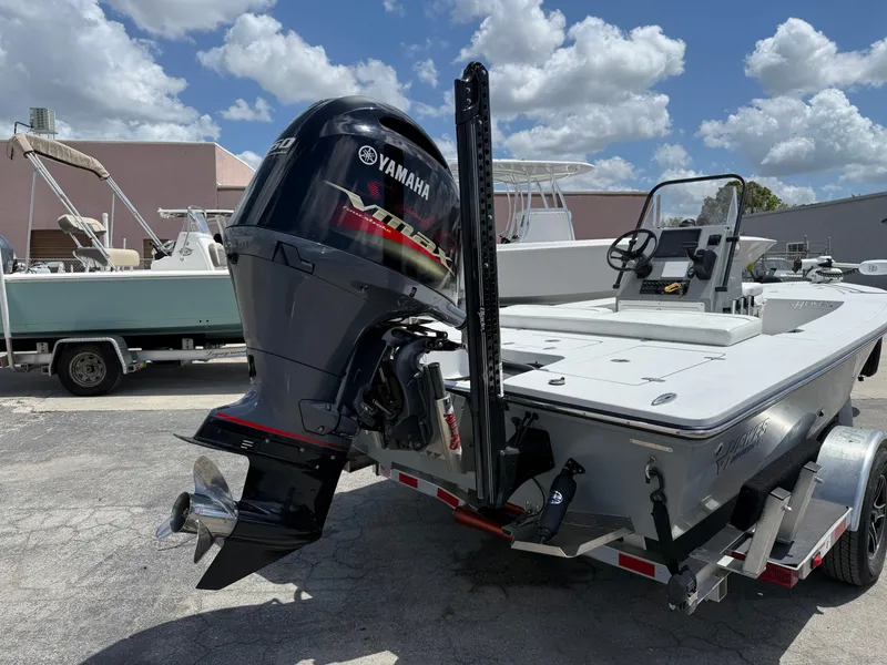 Slide: The Image of 2023 Hewes 18 Redfisher boat with Yamaha outboard motor, parked outdoors under a cloudy sky. - 8