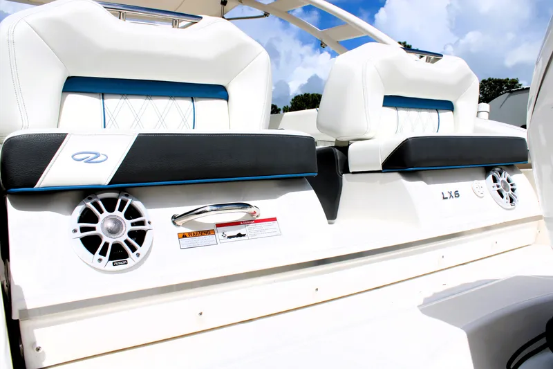 Slide: The Image of 2023 Regal LX6 boat interior with white and black seating, speaker, and blue accents. - 14