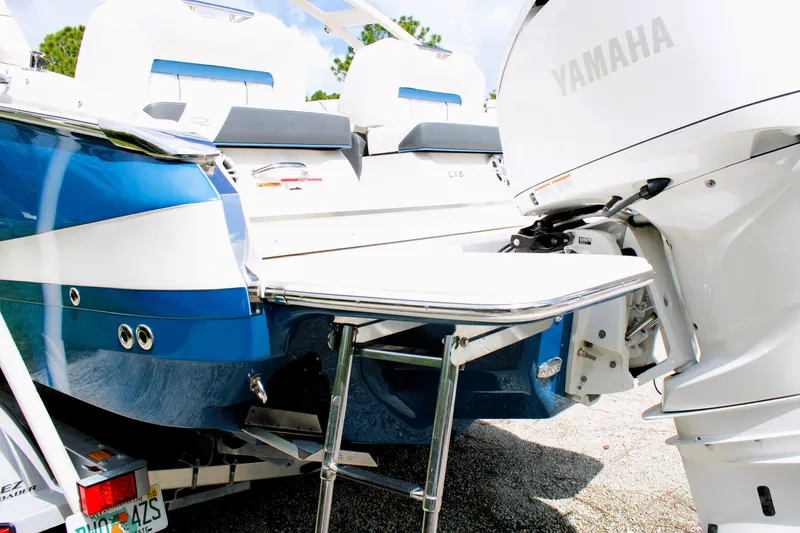 Slide: The Image of 2023 Regal LX6 boat with Yamaha engine, featuring a swim platform and seating area. - 16