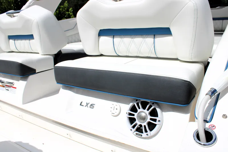 Slide: The Image of 2023 Regal LX6 boat interior with white and black seating, speaker detail. - 19