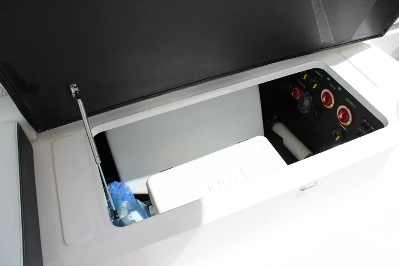 Slide: The Image of 2023 Regal LX6 boat storage compartment with open lid and visible controls. - 23