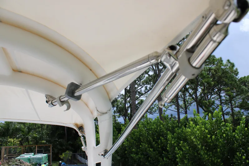 Slide: The Image of 2023 Regal LX6 boat canopy support rods with lush greenery background. - 25