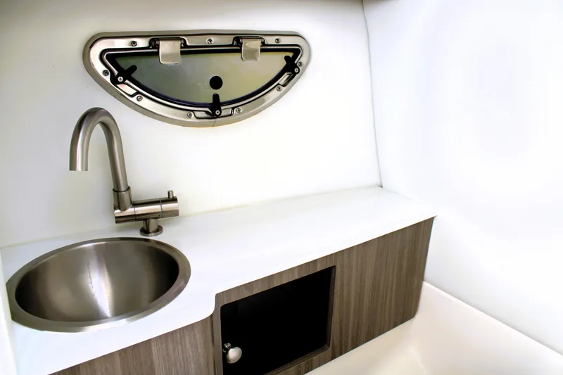 Slide: The Image of 2023 Regal LX6 boat interior with sink, faucet, and porthole window. - 33