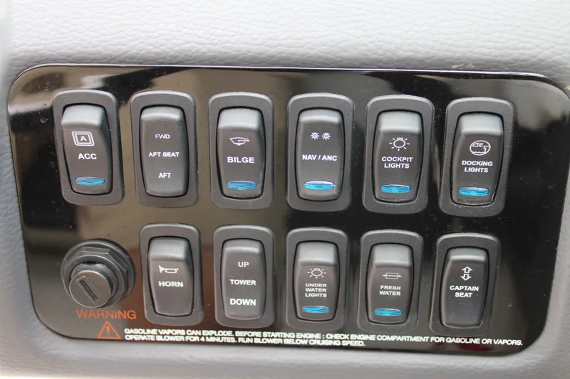Slide: The Image of Control panel of a 2023 Regal LX6 boat with various switches and warning label. - 39