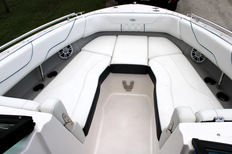 Slide: The Image of 2023 Regal LX6 boat interior with white cushioned seating and cup holders. - 46