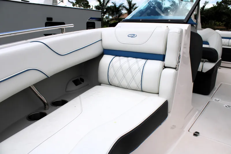 Slide: The Image of 2023 Regal LX6 boat interior with white leather seating and blue accents. - 48