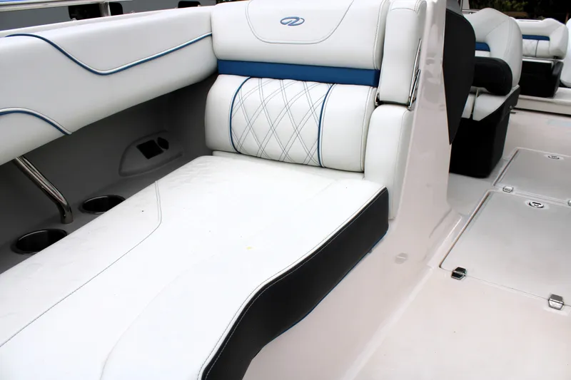 Slide: The Image of 2023 Regal LX6 boat interior with white and blue cushioned seating. - 49