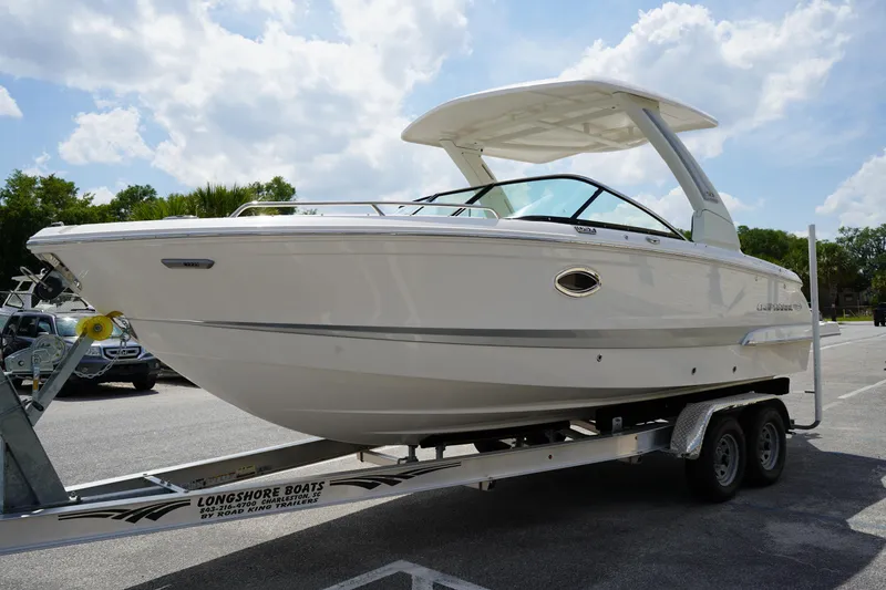 Slide: The Image of 2025 Chaparral 270 OSX boat on trailer under a sunny sky. - 2