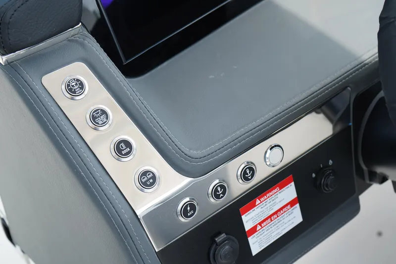 Slide: The Image of Control panel of 2025 Chaparral 270 OSX boat with various buttons and warning label. - 24