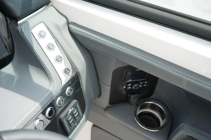 Slide: The Image of 2025 Chaparral 270 OSX boat dashboard with controls and cup holder. - 27