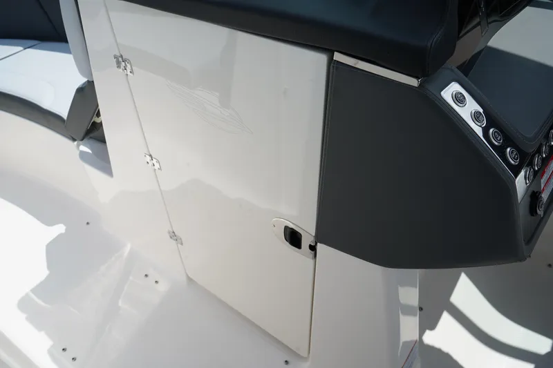 Slide: The Image of 2025 Chaparral 270 OSX boat interior, featuring sleek control panel and storage compartment. - 31