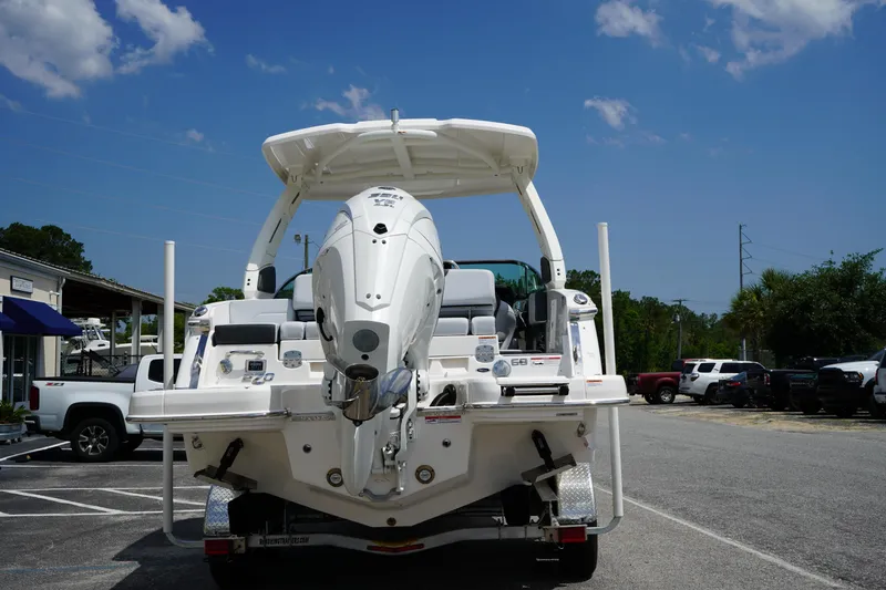 Slide: The Image of 2025 Chaparral 270 OSX boat rear view in parking lot under blue sky. - 5