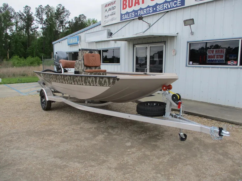 Slide: The Image of 2025 Avid 18 Rogue CC boat on trailer outside dealership, featuring camouflage design and brown seating. - 1