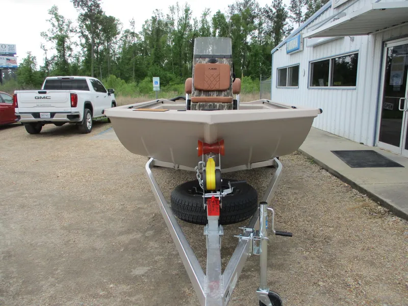 Slide: The Image of 2025 Avid 18 Rogue CC boat on trailer, parked outside dealership, with trees in background. - 2