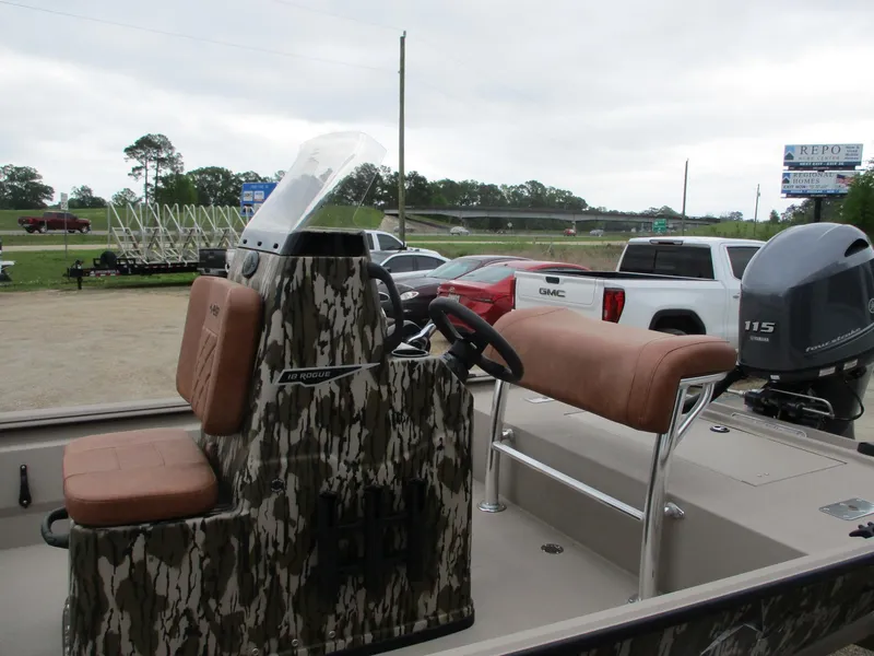 Slide: The Image of 2025 Avid 18 Rogue CC boat with camo design, brown seats, and 115 horsepower outboard motor. - 5