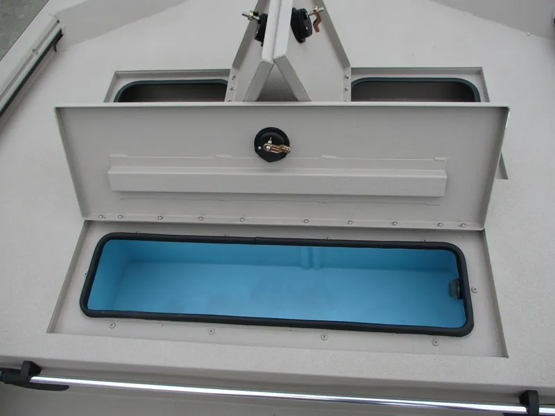 Slide: The Image of Avid 18 Rogue CC 2025 boat storage compartment with open hatch and blue interior. - 9